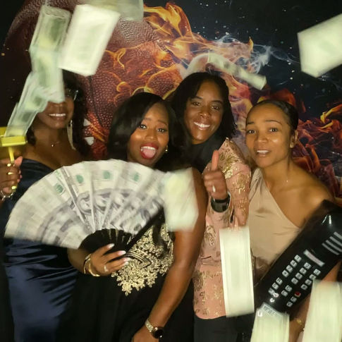 Friends laughing and posing with cash props